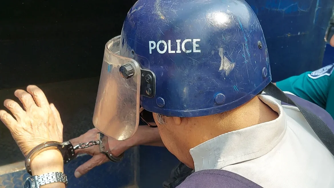 হাতকড়া ও হেলমেট পরিহিত কামরুল ইসলাম