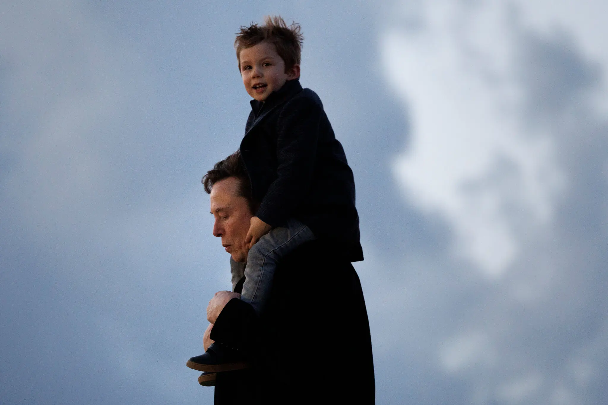 একটি ছবিতে এলন মাস্ককে একটি শিশুকে কাঁধে নিয়ে হাঁটতে দেখা যাচ্ছে। বেশ কয়েকজন নারীর সঙ্গে ১৩টি সন্তানের জনক হওয়া মাস্কের মতে জন্মহার কমে যাওয়ার সামাজিক ঝুঁকির বিরুদ্ধে লড়াইয়ের একটি উপায়।