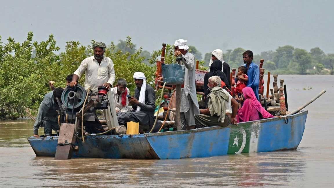 কাসুর জেলার চাঁদা সিংহ ওয়ালা গ্রামে বন্যাকবলিত এলাকায় নিজেদের জিনিসপত্র নিয়ে পার হচ্ছেন মানুষজন।